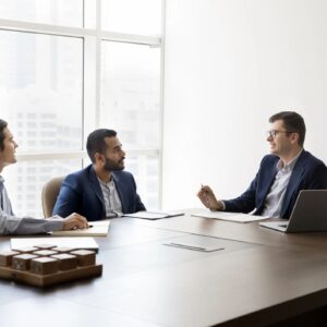 Diverse team of male business leaders talking at table